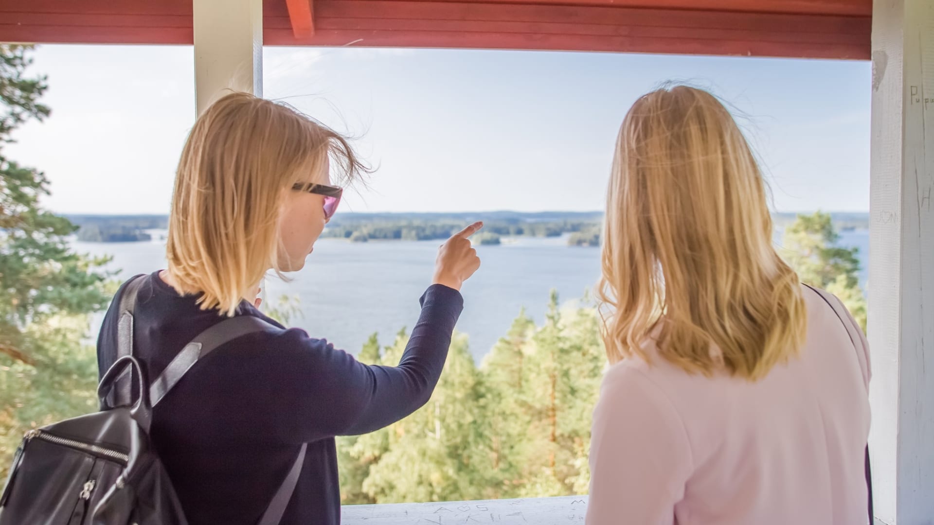 Kaksi nuorta naista Vehoniemen näkötornissassa järvimaisemaa ihailemassa.