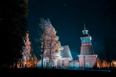 Petäjäveden vanha kirkko valaistuna yöllä.