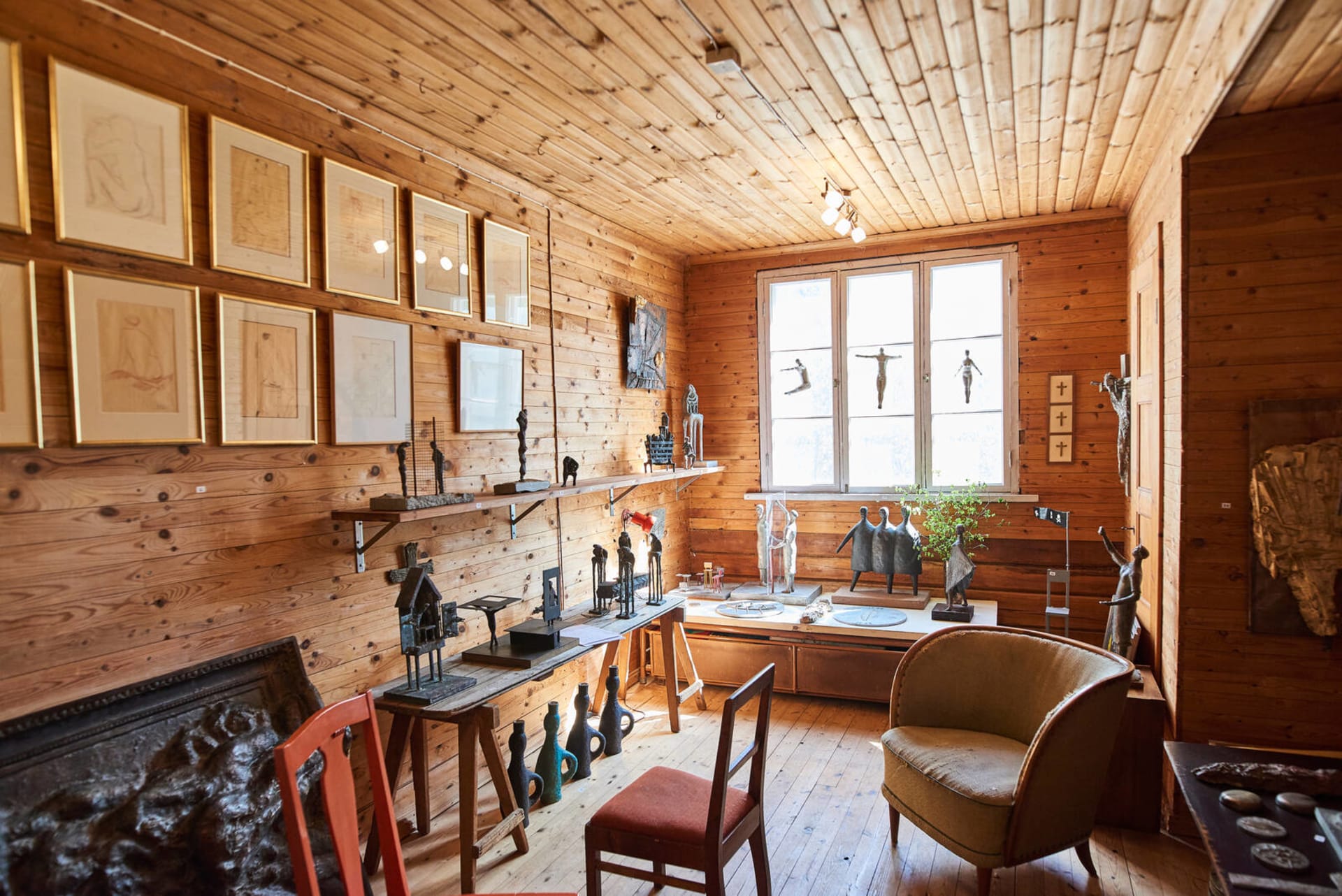 Huone, jossa on seinillä, ikkunoilla ja pöydillä esillä Ossi Somman taideteoksia