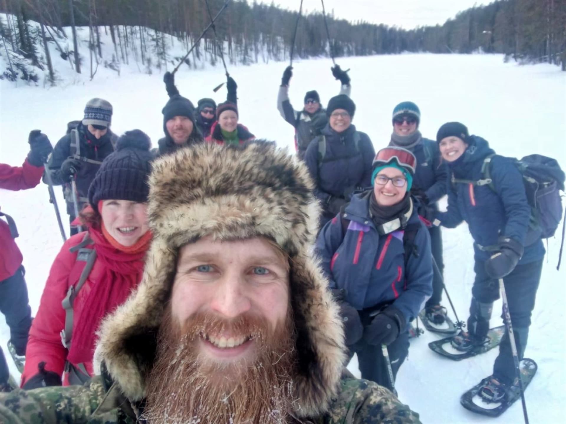 A selfie of the smiling guide surrounded by the group of snowshoers.