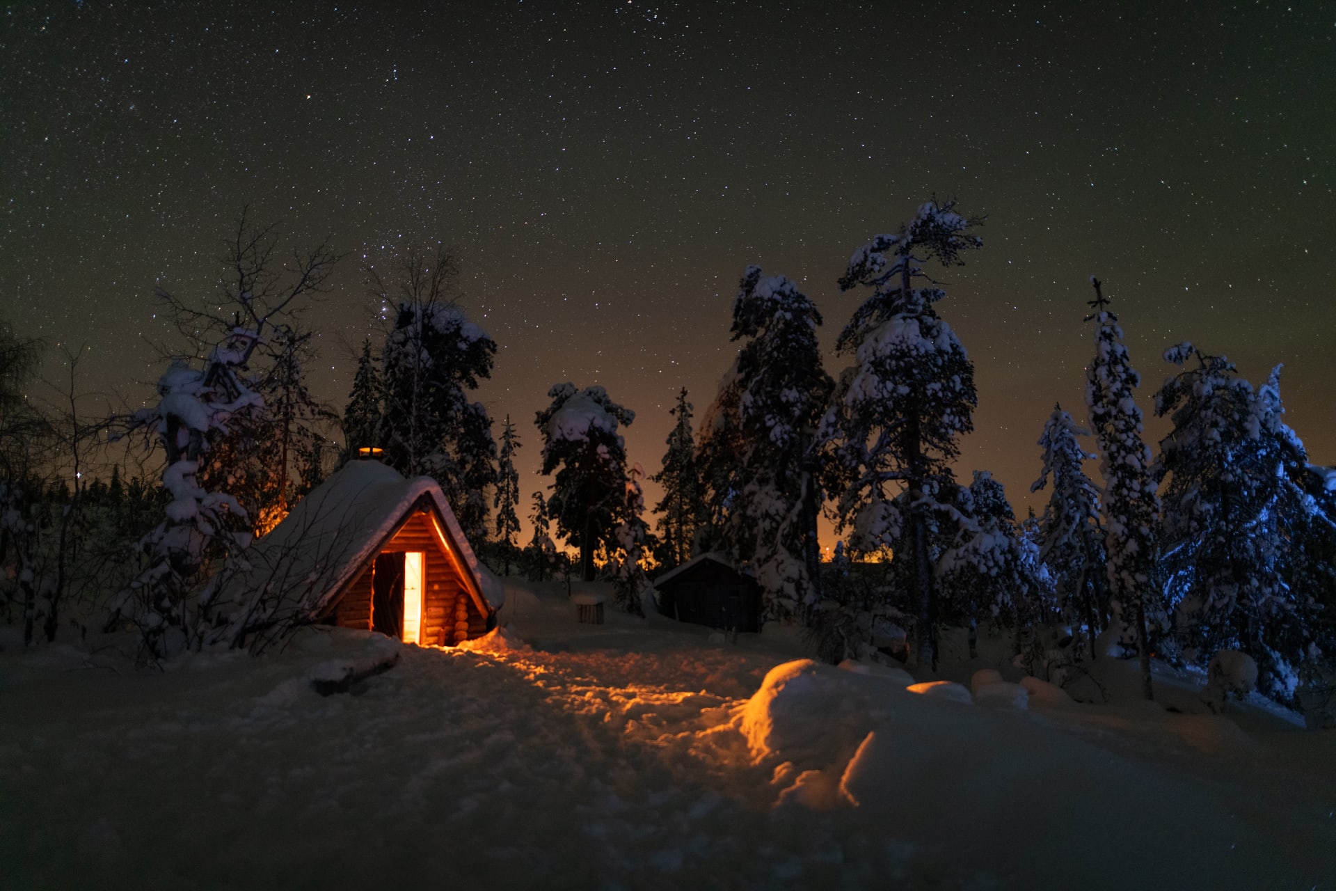 Stars lighting up the sky and fire light coming from a teepee