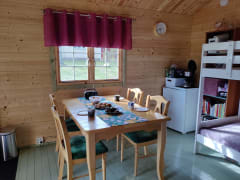 Satukurki-mökissä on pieni keittiönurkkaus ja ruokapöytä.