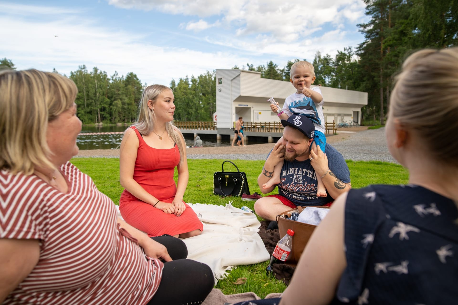 Family is sitting by the Kirjaslampi in Valkeakoski.