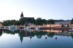 Naantali old town and church skyline reflects on the sea at dusk.