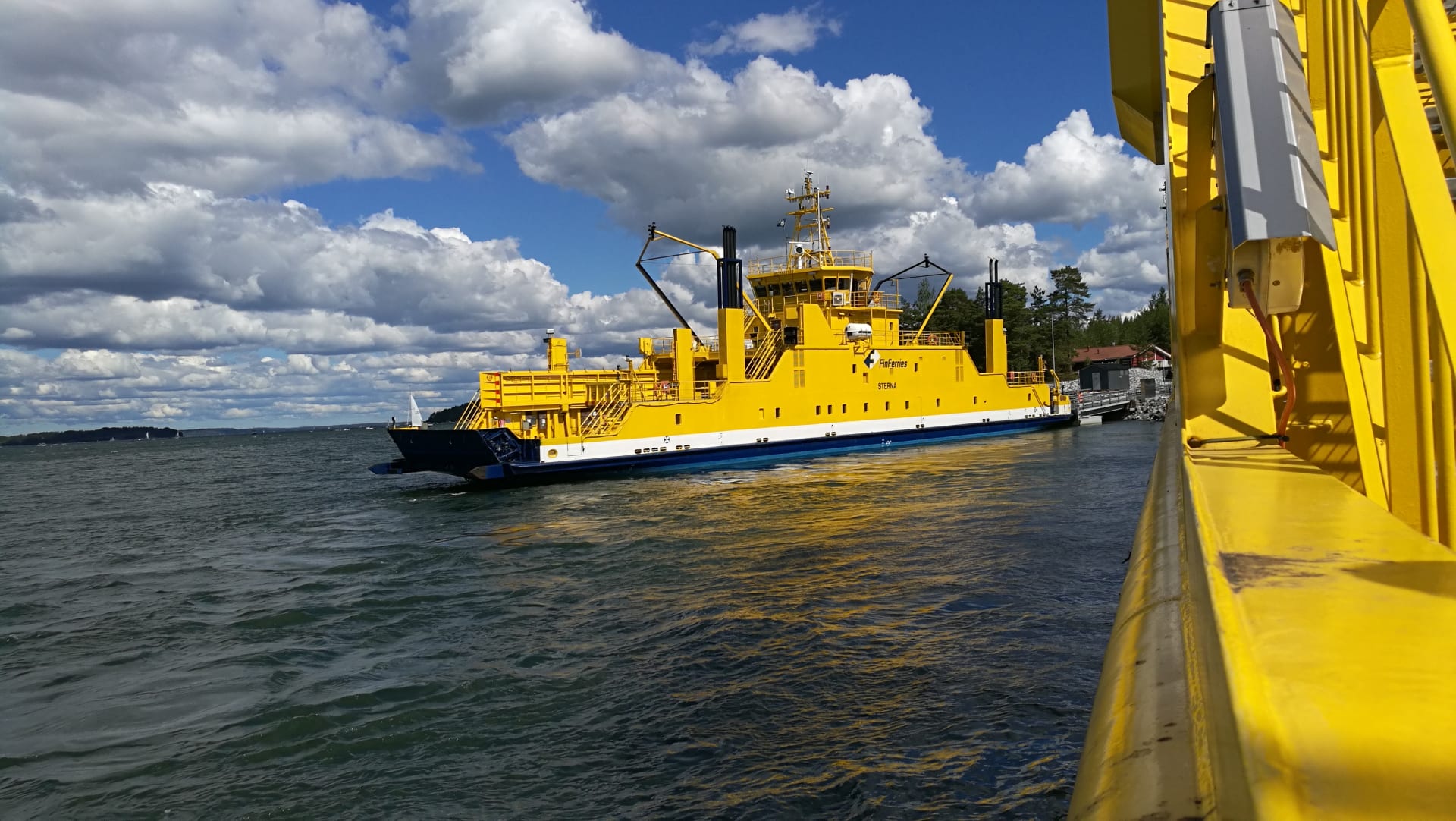 Yellow ferry travelling in the Finnish Archipelago.