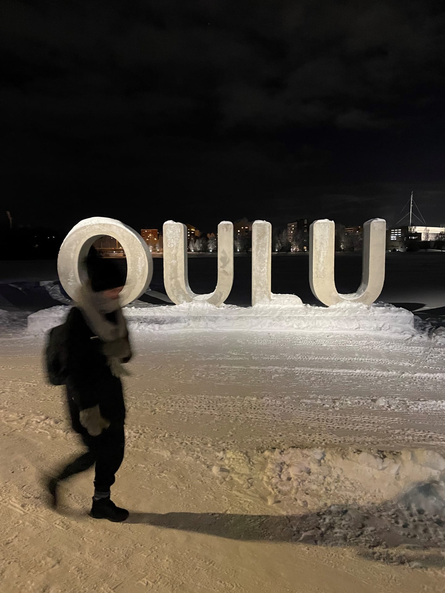 A person in front of big OULU letters.