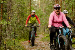 A man and two women fatbiking on the trail