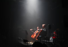 Two cellists in a spotlight