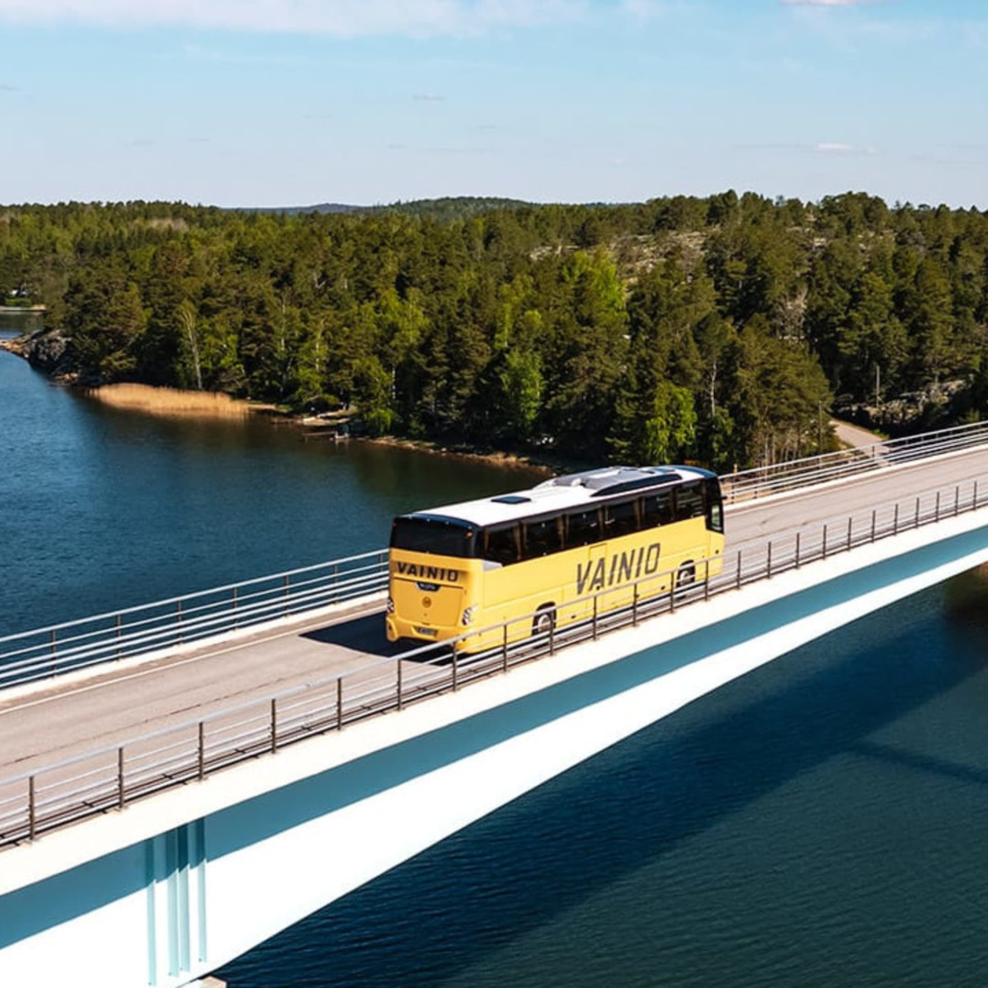 yellow bus on a bridge over the sea