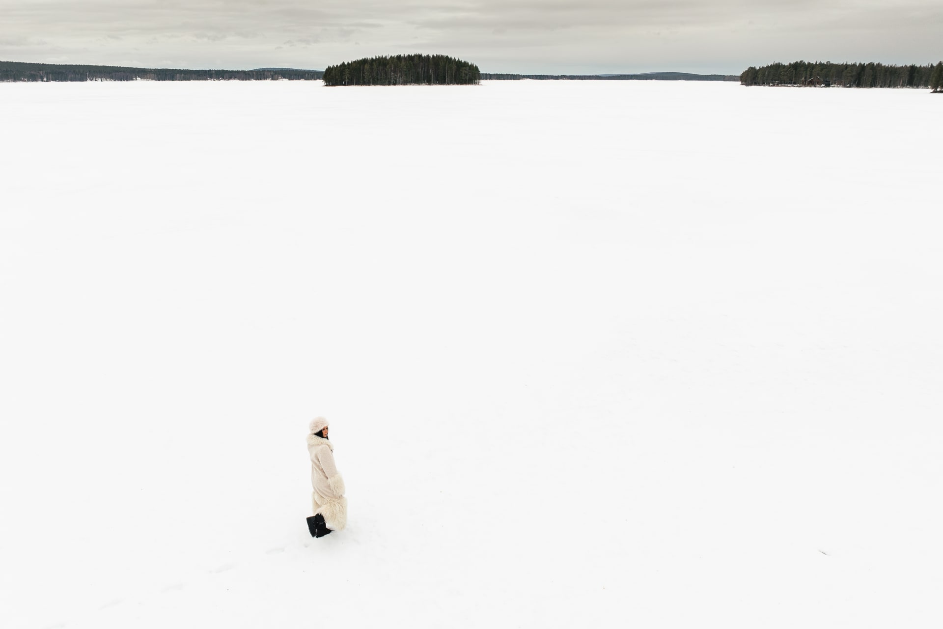 A woman on frozen Lake Norvajärvi at Skýra Retreat