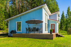 Talo edestä, näkyvissä myös terassi kalusteineen. Front of the house with the terrace.