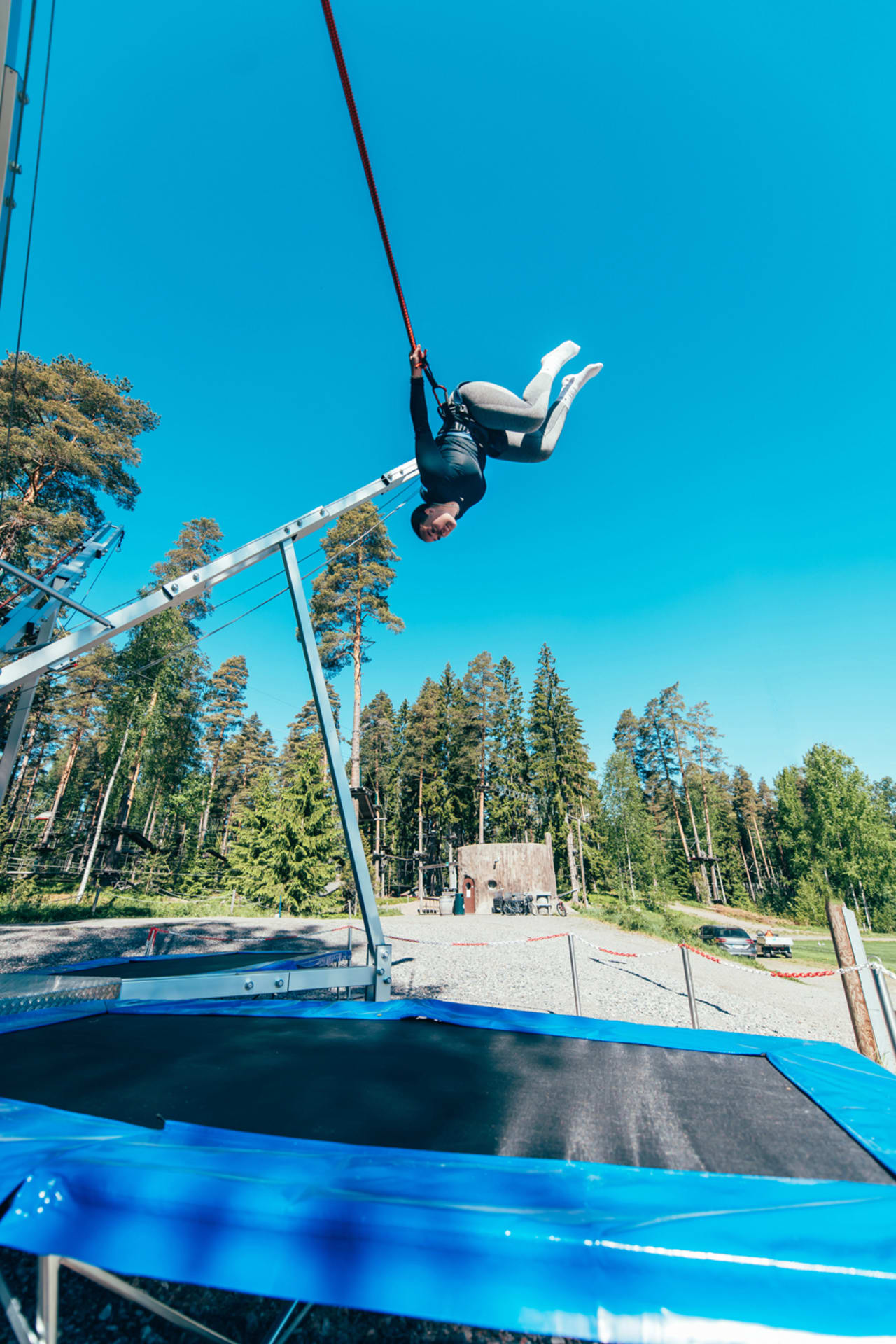 Nainen tekee takaperin volttia Bungee-trampoliinilla.