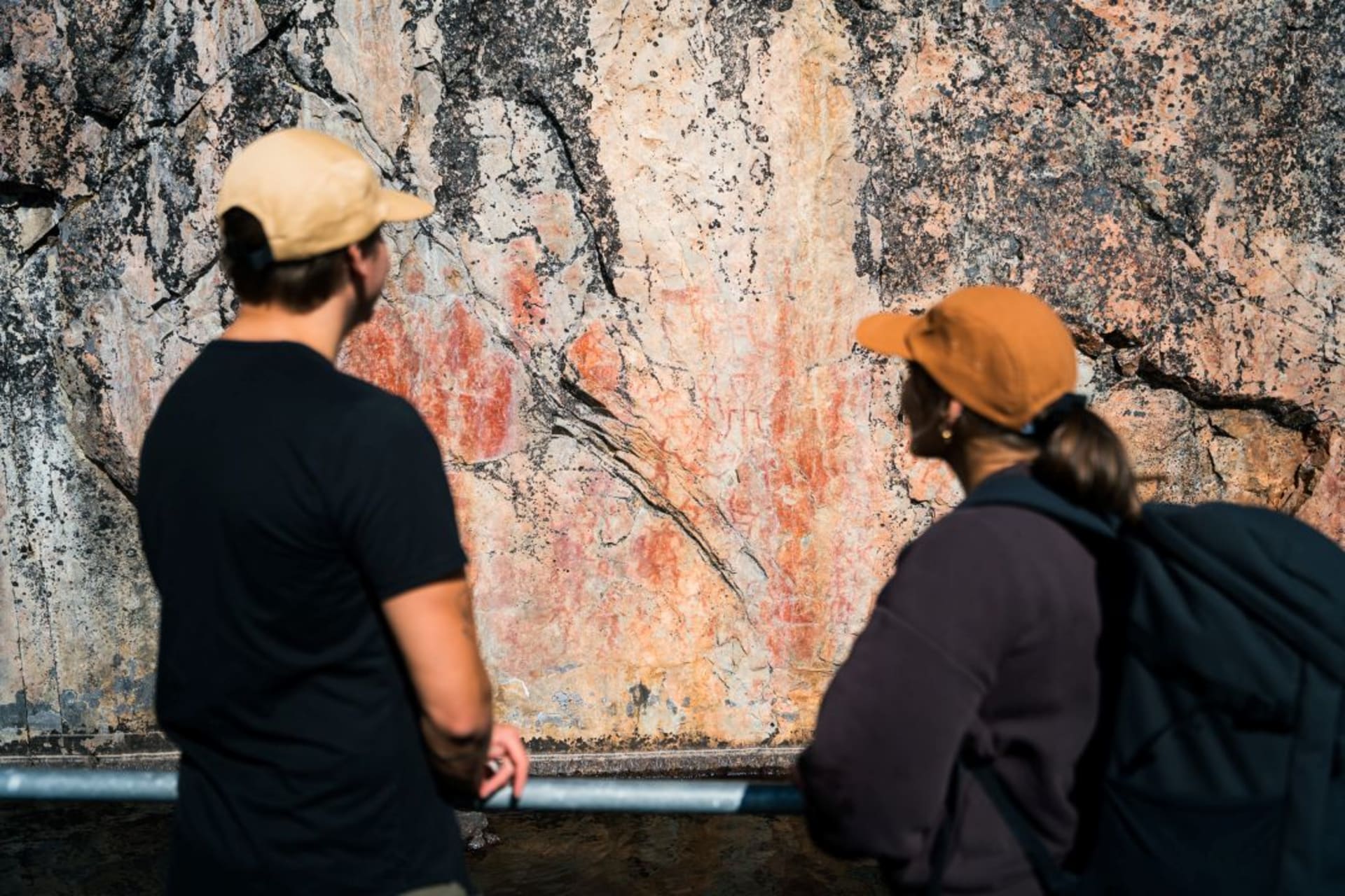 Henkilöt ihailevat värikallion kalliomaalauksia