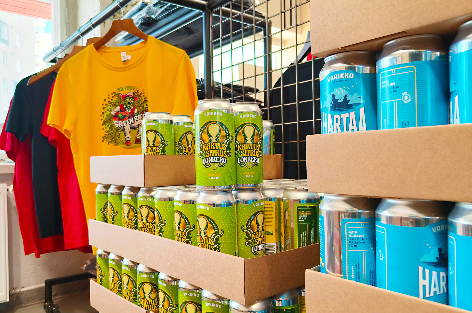 Colorful selection of Varikko craft beer cans and a unique branded t-shirt in the brewery shop