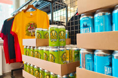 Colorful selection of Varikko craft beer cans and a unique branded t-shirt in the brewery shop