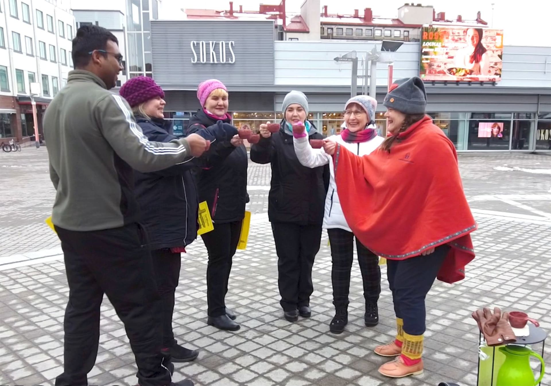 Man and four ladies raising toast with Good Will Elf