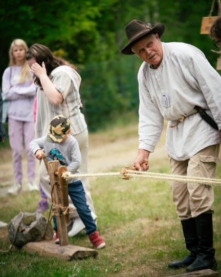 Kaikkien aikojen maatalousnäyttely heinäkuun alussa, ihmiset pukeutuvat vanhan ajan mukaan, lapsi kokeilee käyden punomista.