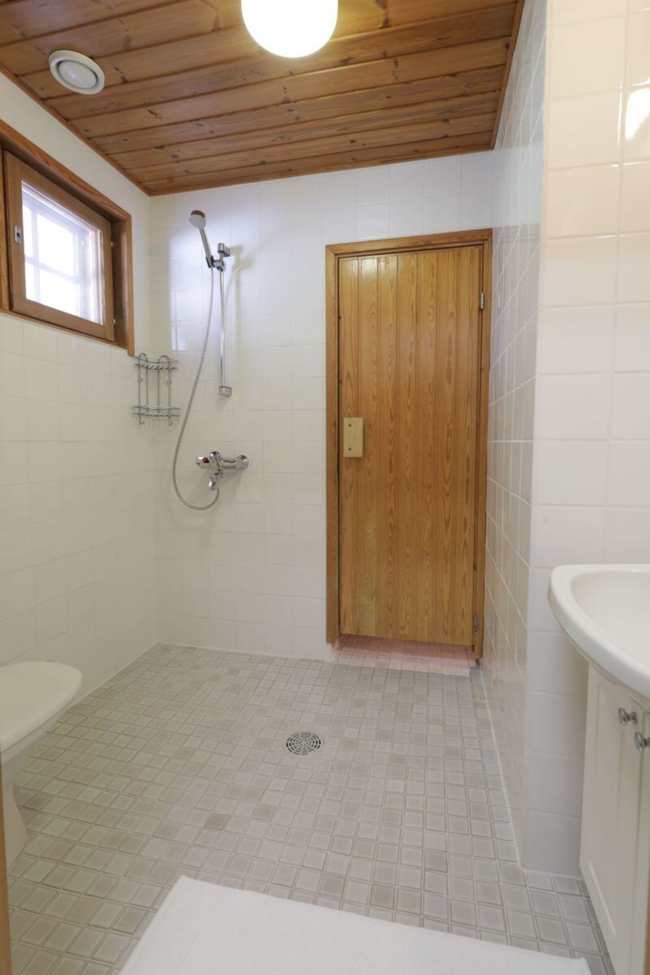 Hiisi Lodge indoor sauna with shower and WC.