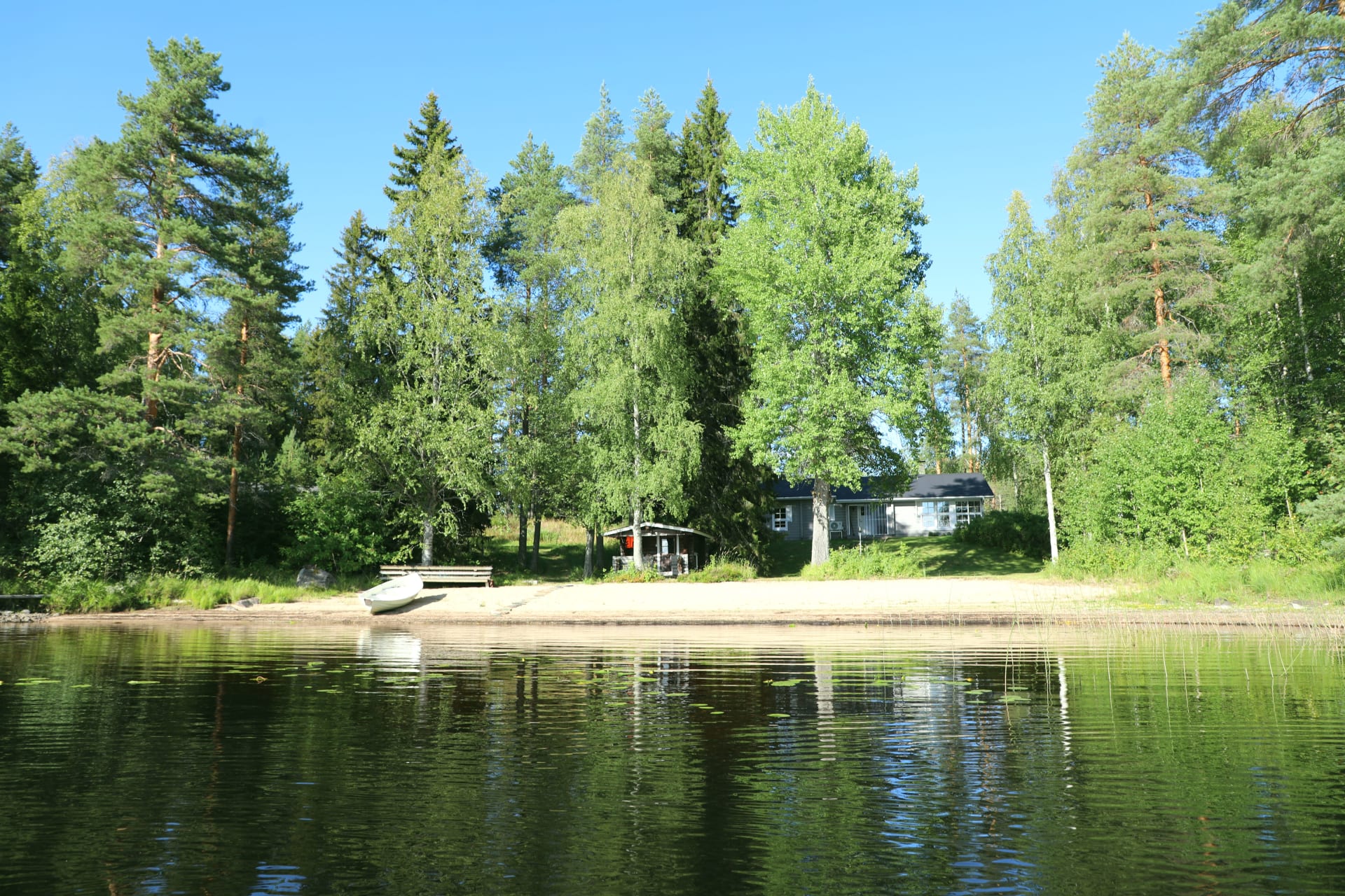 Hiisi Lodge waterfront with sandy beach.