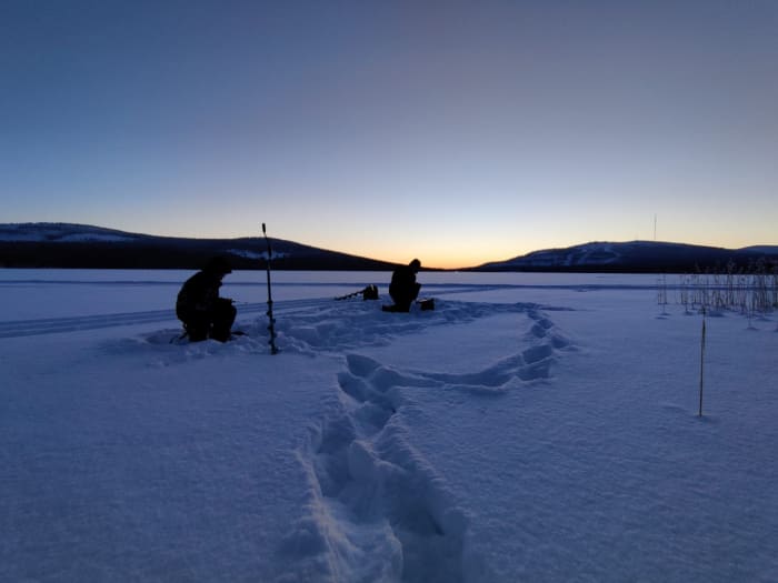 Ice Fishing in the evening sun at Lake Pyhäjärvi