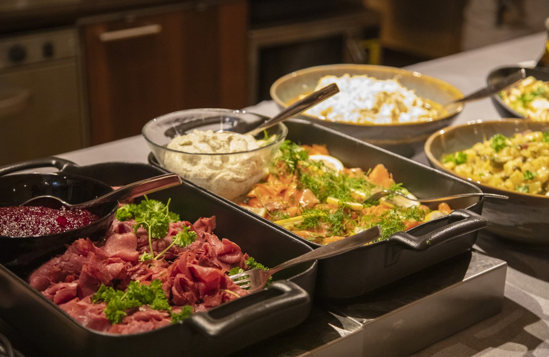 Ylläskammin Revontuli-illallisen buffet-pöydässä Lapin herkkuja kauniissa astioissa. 