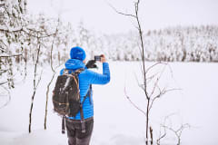 Mies valokuvaa talvista maisemaa.