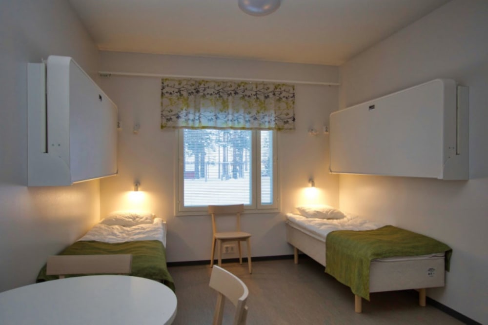 Hotel room with beds for four persons and a table
