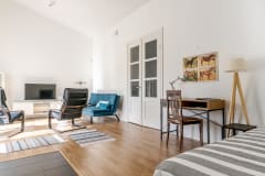 Olohuone, jossa vuodesohva, nojatuolit ja televisio. Living room with a sofa bed, armchairs, and a TV.