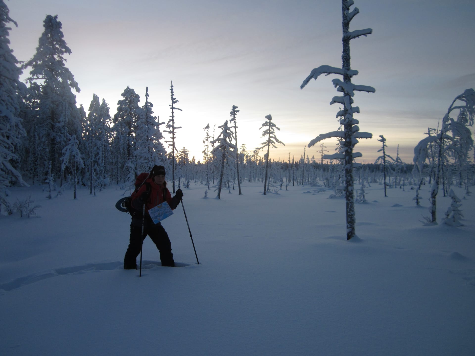 A lady snowshoeing in a snowy, blue scenery
