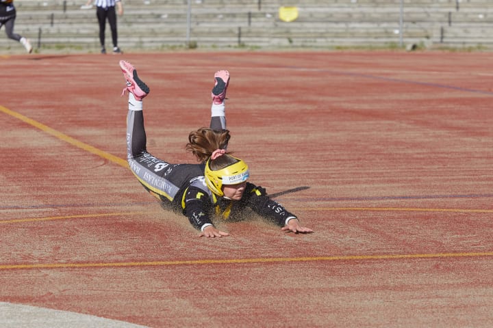 Pesäpalloilija syöksyy pesälle.