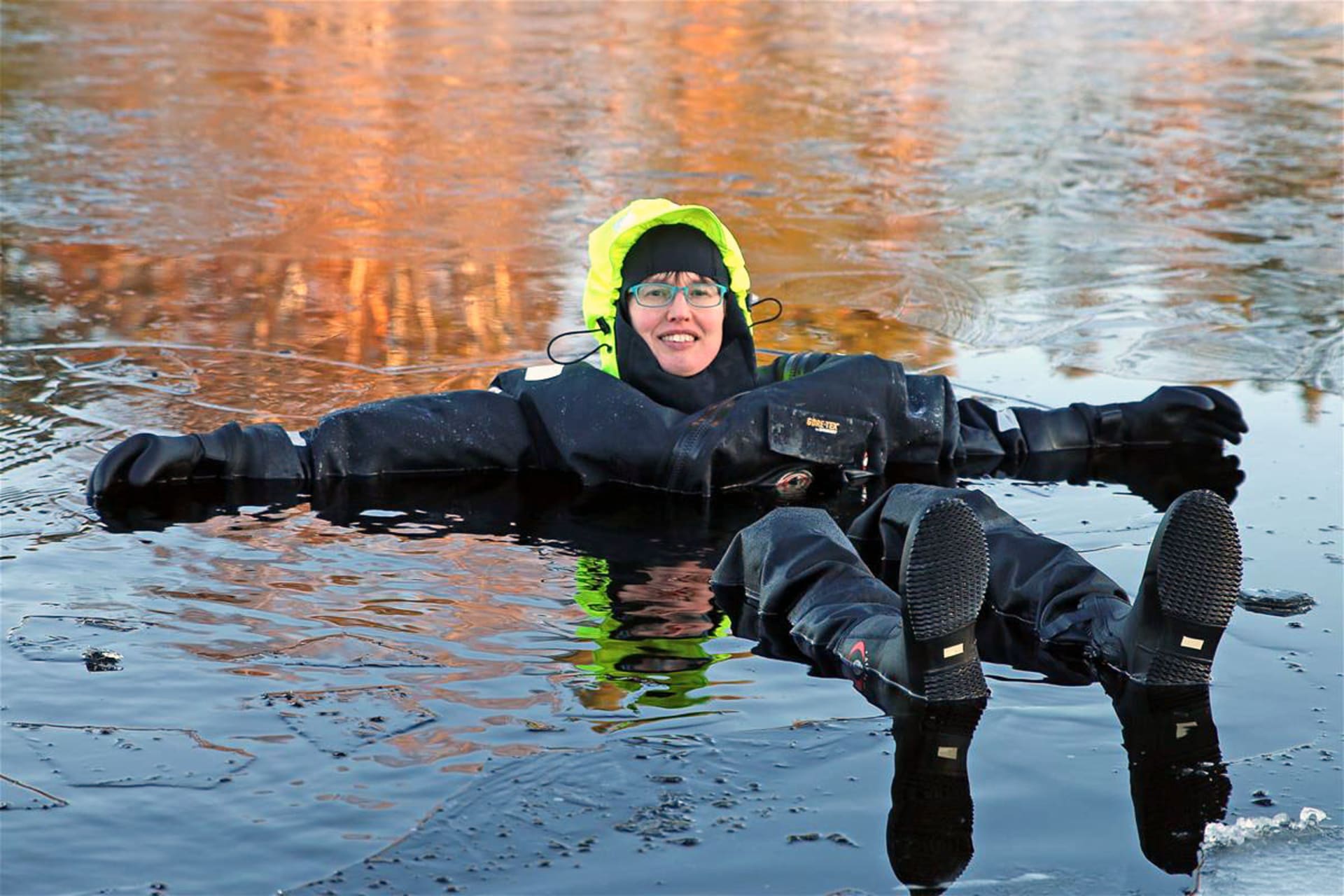 Woman in a drysuit floating in the lake