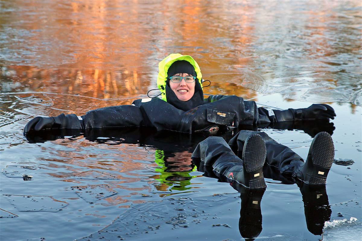 Woman on a drysuit floating in the lake