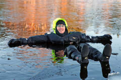 Woman in a dry suit floating in Lake Saimaa in winter