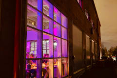 The historic Varikko brewery building glowing with purple lights during a Nordic evening