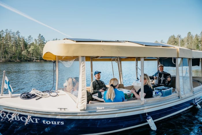 Skipper playing accordeon on Saimaa story cruise Ecoboat lake Saimaa Puumala Lakelandgte