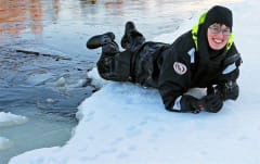 Woman in a dry suit laying on ice in Lake Saimaa in Finland