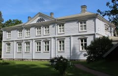 Kartanon julkisivu kylpee kesäauringossa - kartanolle saavuttaessa tämä kaunis näkymä avautuu tulijalle