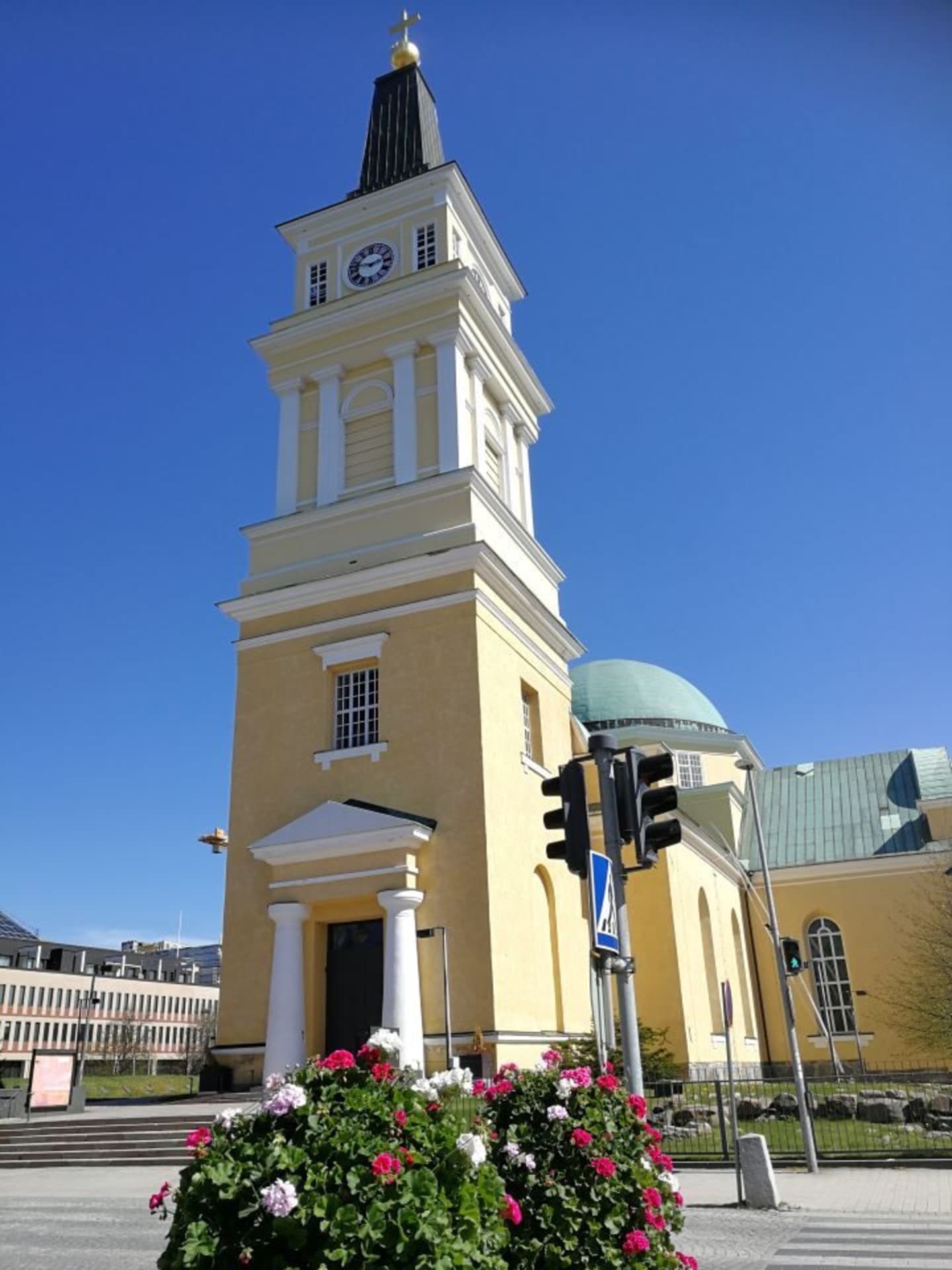 Yellow Oulu Cathedral church tower against blue sky in summer.