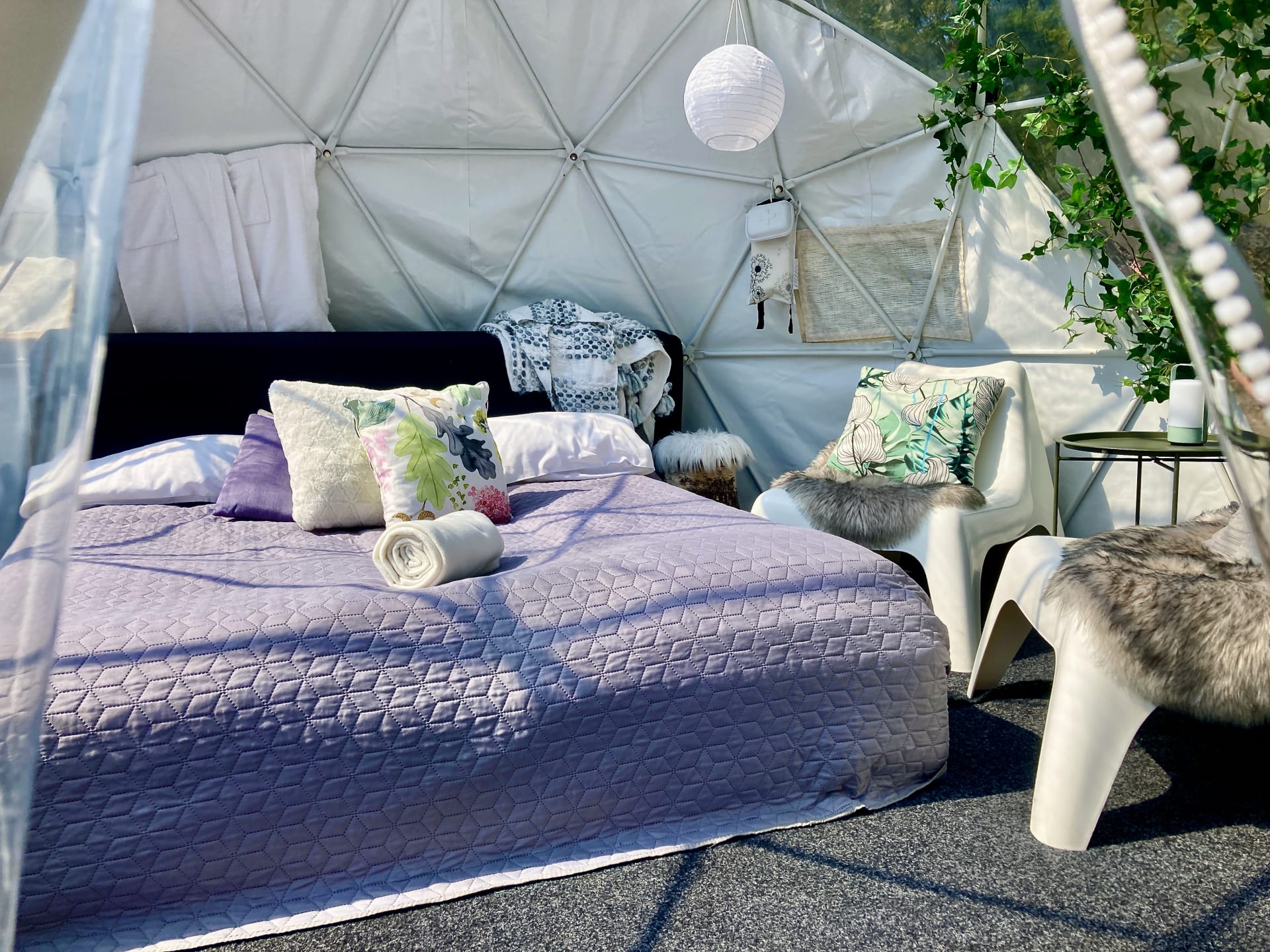 FinnDome-teltan sisätila: pedattu parisänky, ihanat puhtaat vuodevaatteet ja tunnelmallinen glamping-elämys luonnon rauhassa.