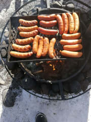Traditional Finnish snack, grilled sausages, on an open fire in Koiteli rapids.