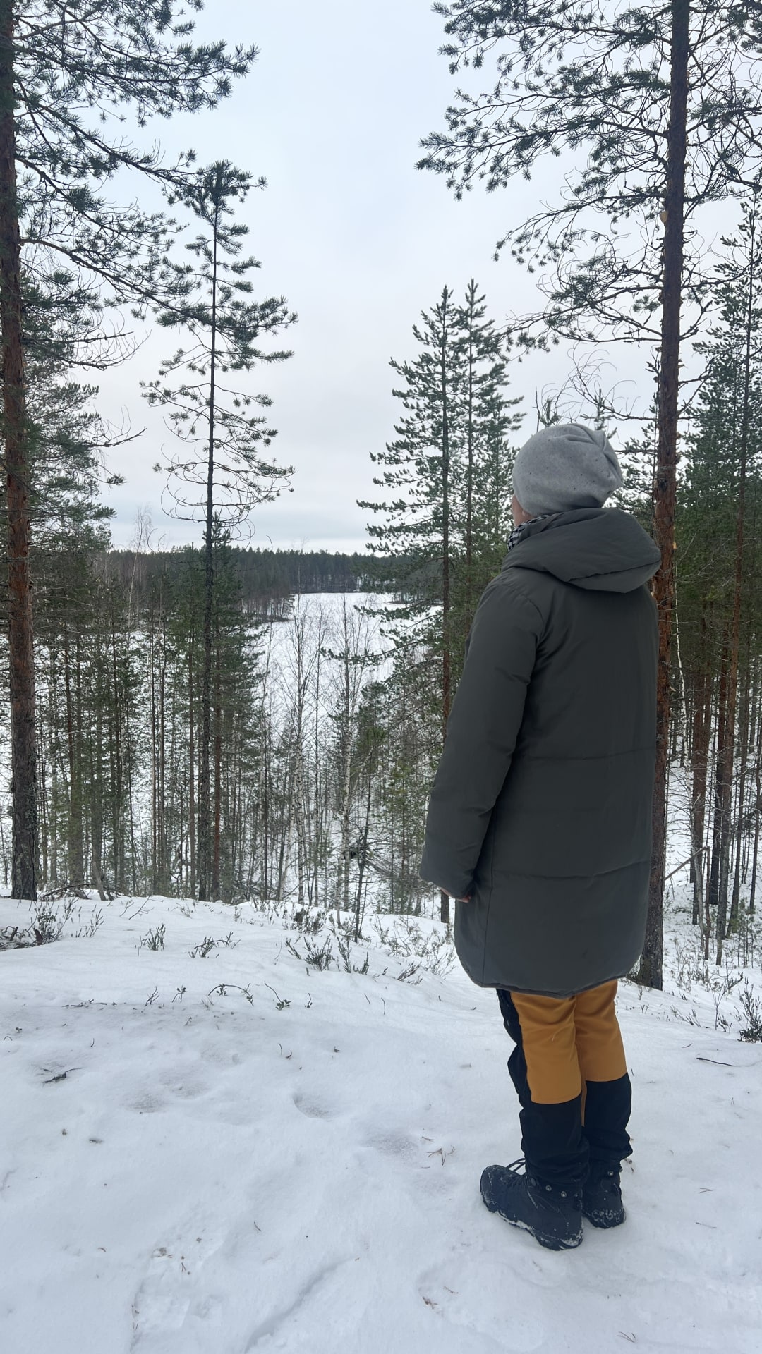 Nainen katselee maisemaa talvisessa metsässä