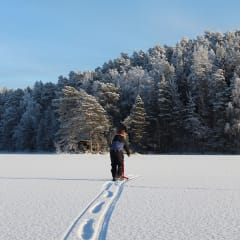 A man walking on an ice and snow towards shelter.