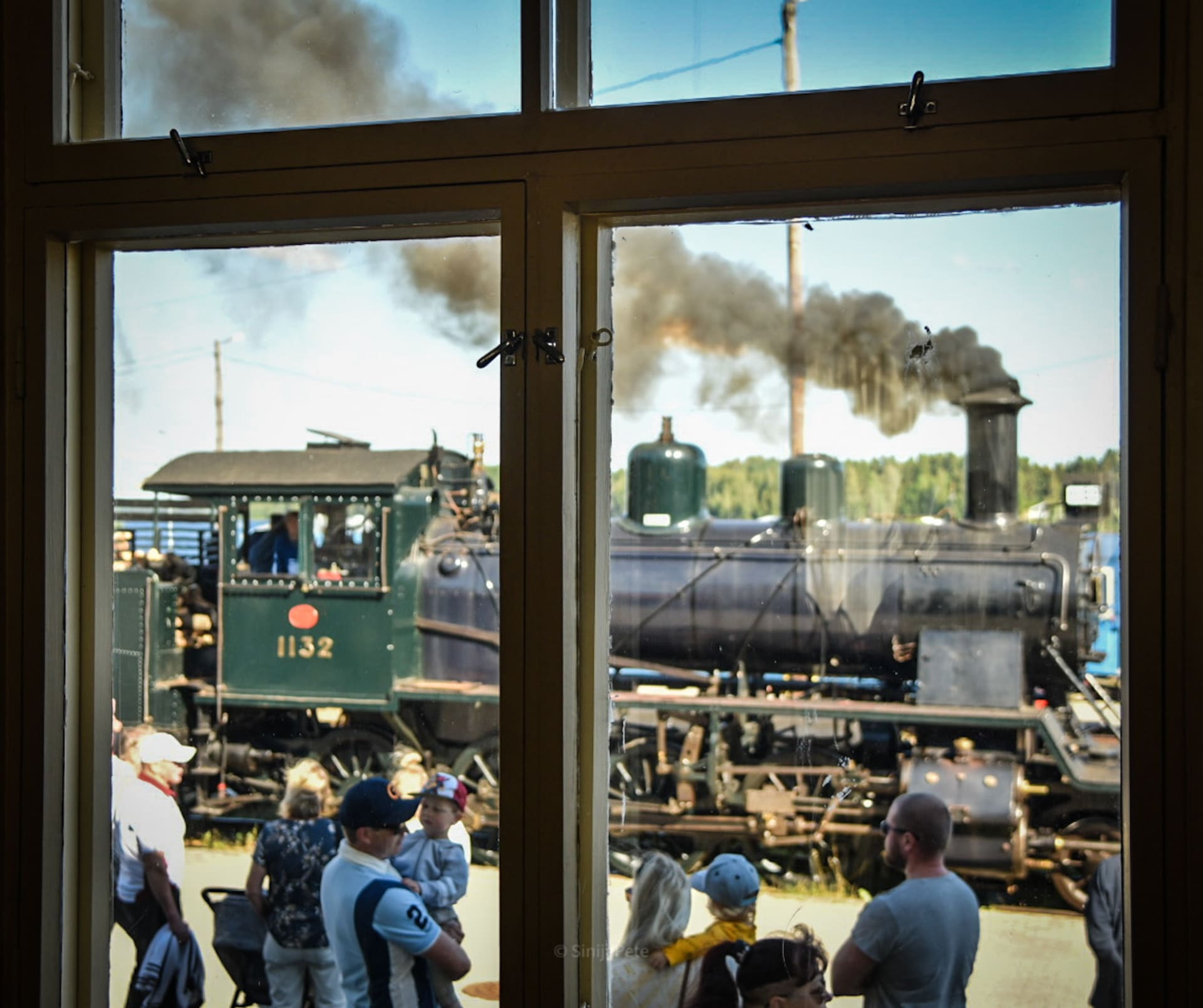 Old moving steam engine through a window