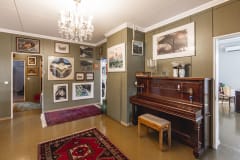 Piano ja tauluja huoneessa.