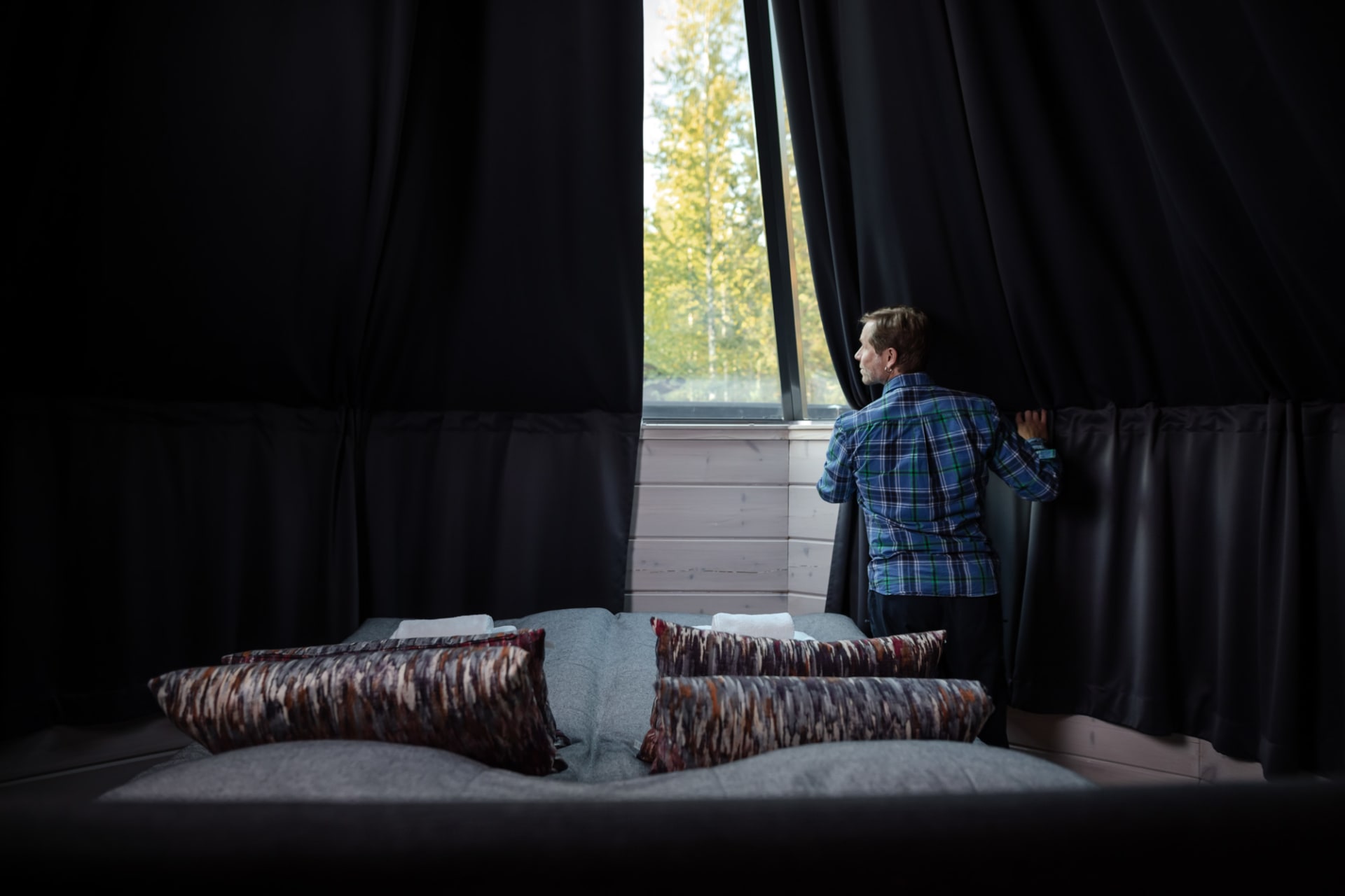 Curtains over the igloo window, a man opening curtains