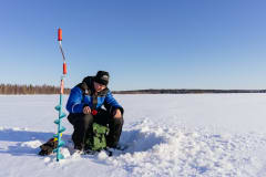 Icefishing by Apukka Resort Wilderness Lake Olkkajärvi