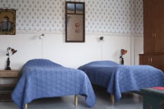 Kaksi pedattua sänkyä vuokrahuoneessa