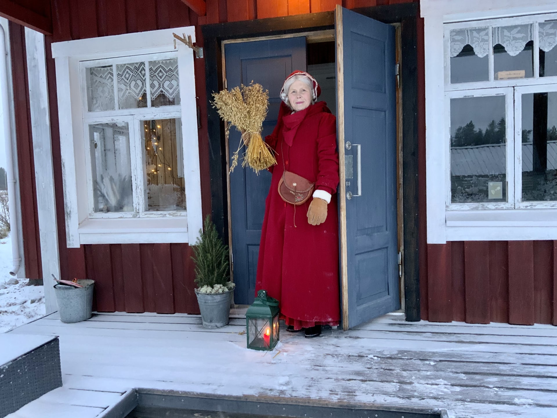 Mrs. Santa Claus Finland at the door of her house welcoming you to the world of Christmas
