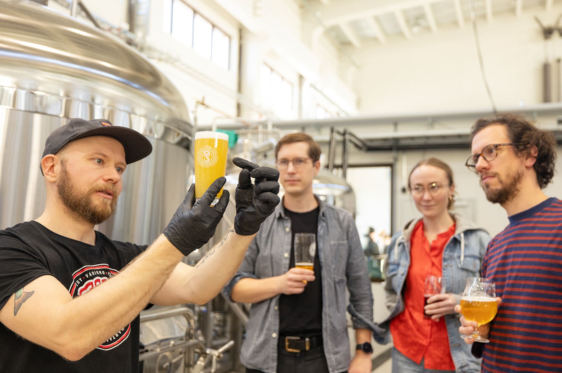 Beer tasting session with a brewer explaining the process in front of massive tanks