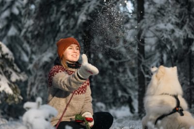 Woman and a dog in the snowy forest